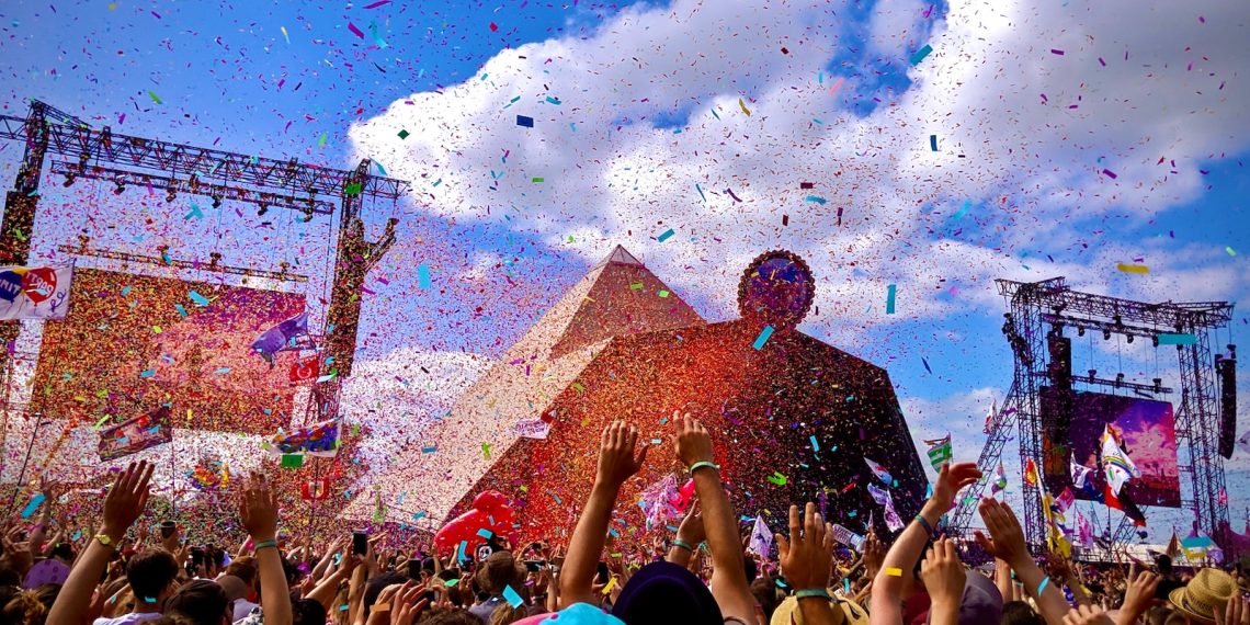 Les 9 festivals culturels incontournables à découvrir en France - plare. a crowd of people at a concert with confetti in the air
