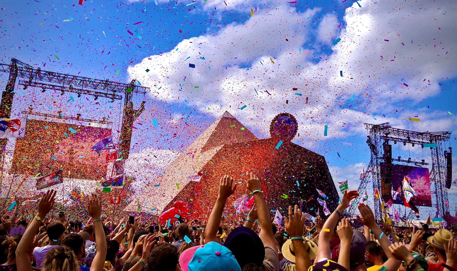 a crowd of people at a concert with confetti in the air
