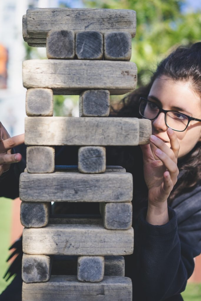 Comment améliorer sa concentration ? - plare. woman playing with wooden blocks