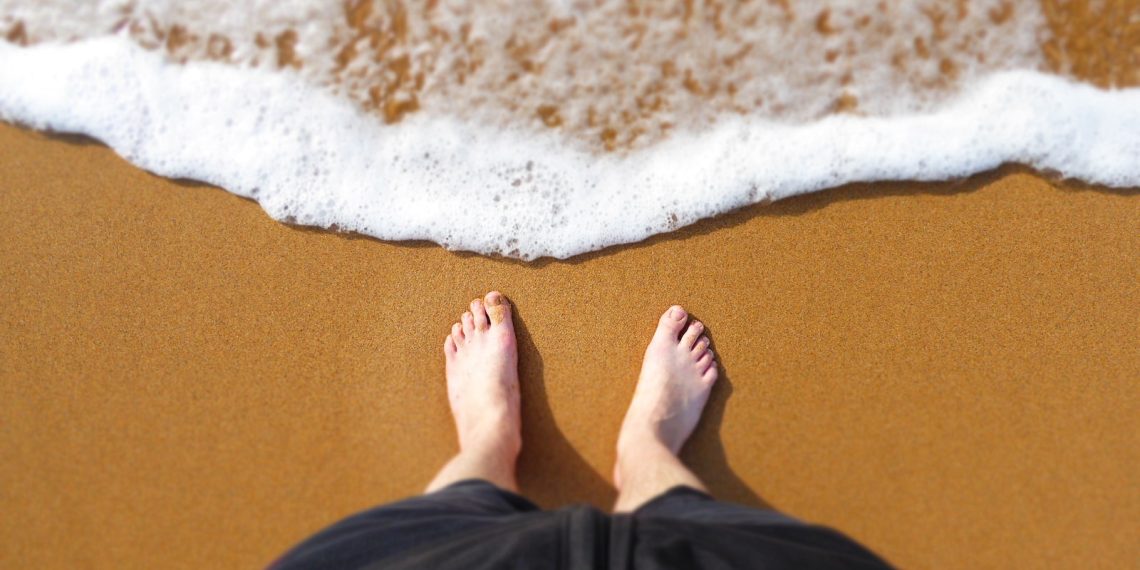 person standing at the edge of the shore