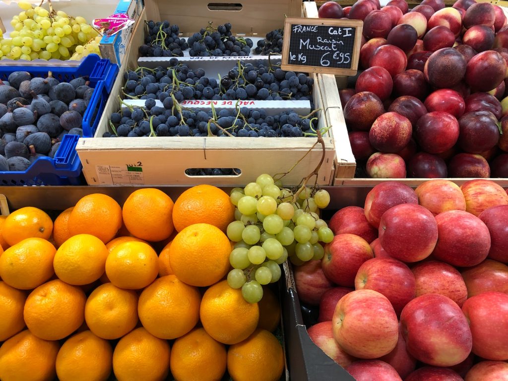 yellow citrus fruit beside red apples and green grapes