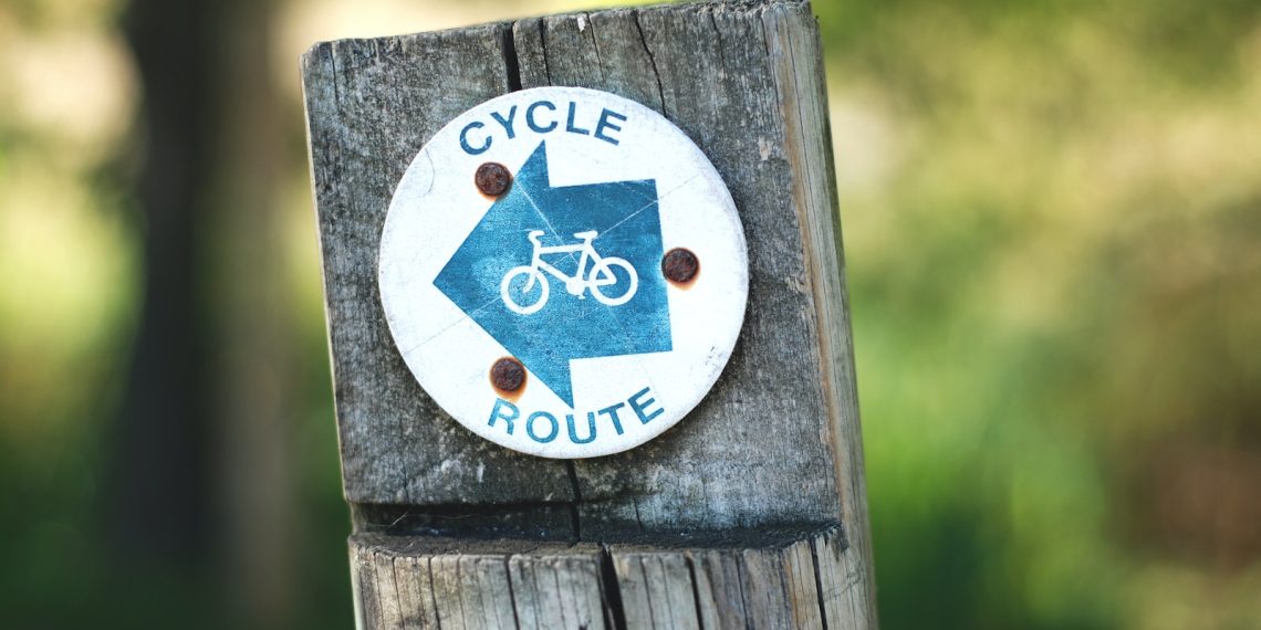 7 conseils pour préserver l'environnement lors d'un séjour en montagne en été - plare. cycle route sign on a wooden post