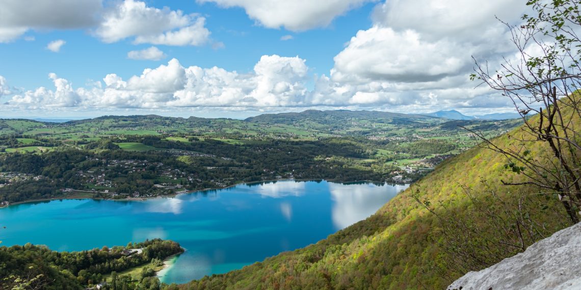 Les 5 meilleures destinations pour un séjour bien-être en montagne en été - plare. a lake surrounded by hills and trees