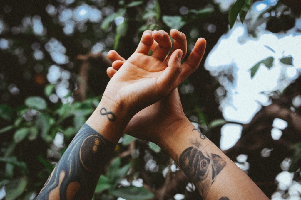 Boostez votre style estival avec les tatouages éphémères tendance ! - plare. person raising his hands near tree