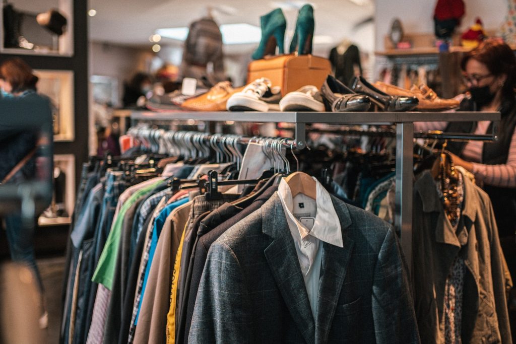 Découvrez la friperie : tendance mode éthique, économique et vintage pour femmes - plare. a rack of clothes and shoes in a store